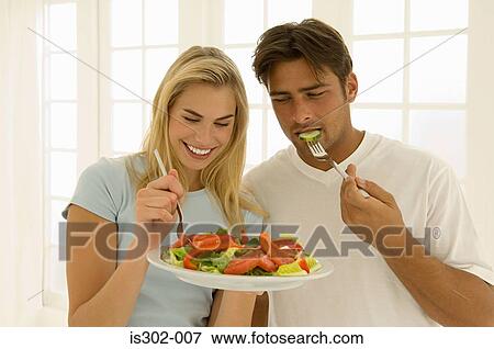 Couple eating salad View Large Photo Image Stock Photo - Couple eating salad. Fotosearch