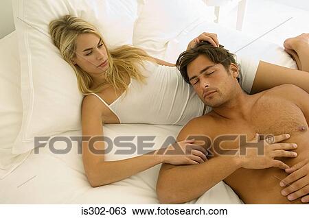 Couple lying on bed View Large Photo Image Stock Image - Couple lying on bed. Fotosearch