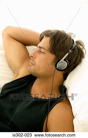 Stock Image - Man listening to headphones. Fotosearch