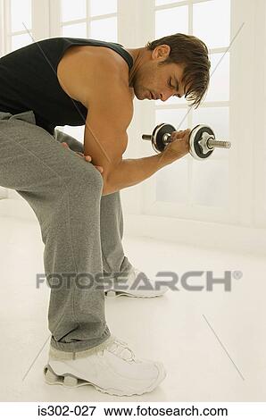 Stock Photo - Man using dumbbell. Fotosearch