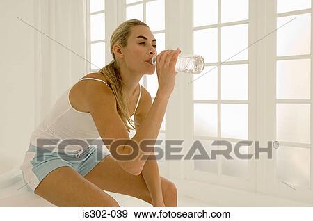 Woman drinking bottle of water View Large Photo Image Stock Photo - Woman drinking bottle of water. Fotosearch
