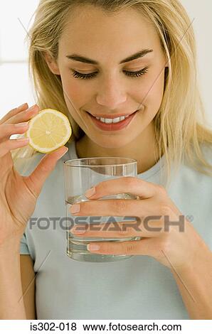 Woman with glass of water and slice of lemon View Large Photo Image Stock Photo - Woman with glass of water and slice of lemon. Fotosearch