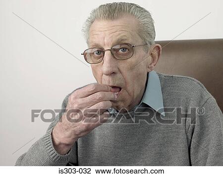 Stock Image - Senior man taking a tablet. Fotosearch