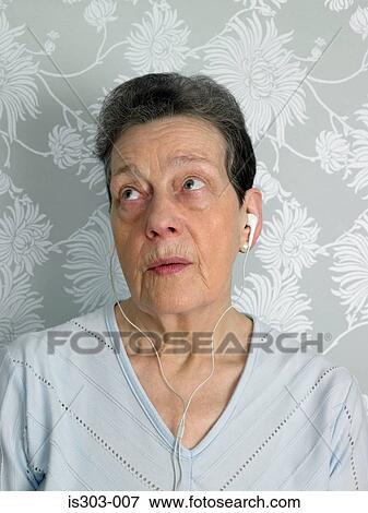 Stock Photo - Senior woman listening to music. Fotosearch