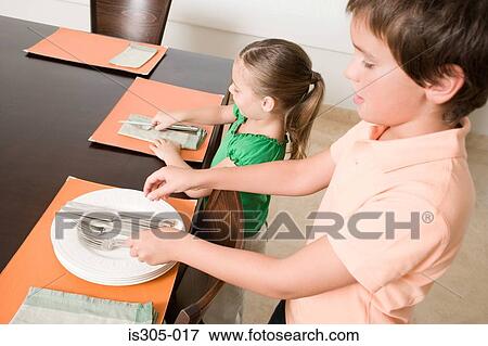 Stock Photo - Brother and sister setting the table. Fotosearch