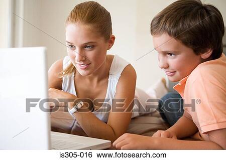 Stock Photograph - Brother and sister using laptop. Fotosearch