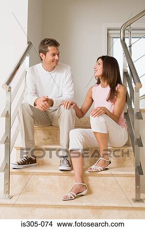 Picture - Couple having conversation on the stairs. Fotosearch