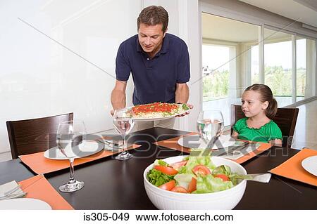 Stock Photo - Father bringing meal to table. Fotosearch