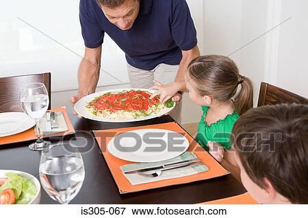 Girl taking spaghetti as father tries to serve meal View Large Photo Image Stock Photo - Girl taking spaghetti as father tries to serve meal. Fotosearch