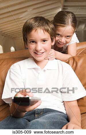 Stock Photo - Sister and brother with remote control. Fotosearch