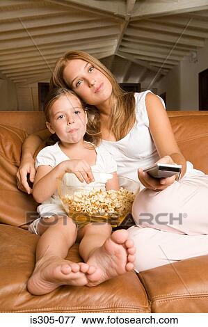 Stock Photo - Sisters watching a movie. Fotosearch