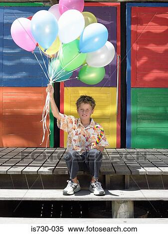 Stock Photography - Boy on step with balloons. Fotosearch