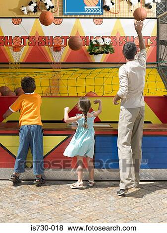 Stock Photo - Family playing on fairground stall. Fotosearch