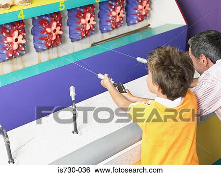 Father and son playing on fairground stall View Large Photo Image Stock Photograph - Father and son playing on fairground stall. Fotosearch