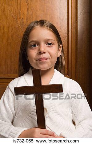 Girl holding a crucifix View Large Photo Image Stock Photography - Girl holding a crucifix. Fotosearch
