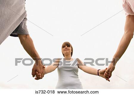 Girl holding hands with parents View Large Photo Image Stock Photo - Girl holding hands with parents. Fotosearch
