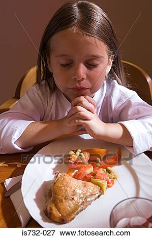Stock Photo - Girl praying before dinner. Fotosearch