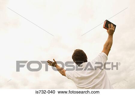 Man holding bible with open arms View Large Photo Image Stock Image - Man holding bible with open arms. Fotosearch