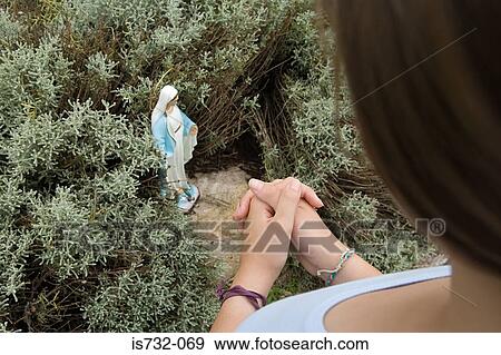 Praying by statue of the virgin mary View Large Photo Image Stock Photo - Praying by statue of the virgin mary. Fotosearch