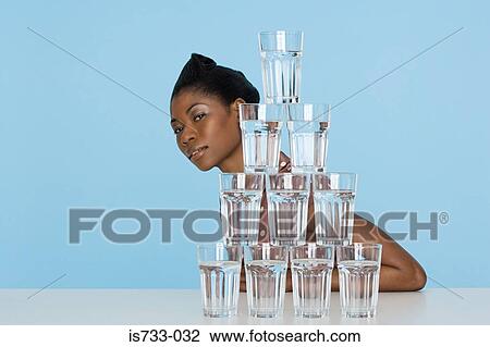 Young woman behind a stack of glasses View Large Photo Image Stock Image - Young woman behind a stack of glasses. Fotosearch
