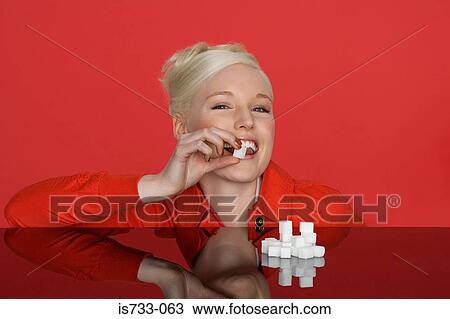 Young woman eating a sugar lump View Large Photo Image Stock Image - Young woman eating a sugar lump. Fotosearch