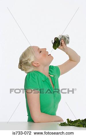 Young woman eating spinach View Large Photo Image Stock Image - Young woman eating spinach. Fotosearch