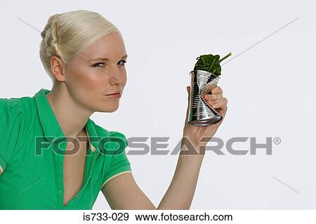 Young woman holding a can of spinach View Large Photo Image Stock Photo - Young woman holding a can of spinach. Fotosearch