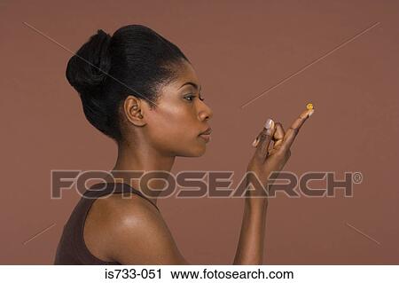 Young woman holding a capsule View Large Photo Image Stock Image - Young woman holding a capsule. Fotosearch