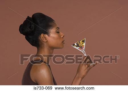 Young woman holding a cocktail glass of vitamins View Large Photo Image Stock Photo - Young woman holding a cocktail glass of vitamins. Fotosearch