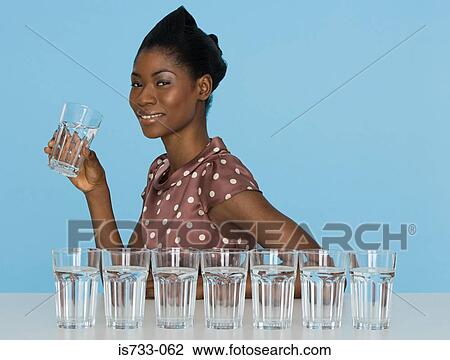 Young woman holding a glass View Large Photo Image Stock Image - Young woman holding a glass. Fotosearch