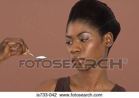 Young woman holding a teaspoon View Large Photo Image Stock Image - Young woman holding a teaspoon. Fotosearch