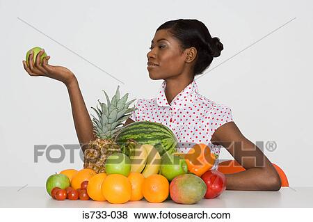 Young woman holding an apple View Large Photo Image Stock Photo - Young woman holding an apple. Fotosearch