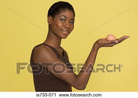 Young woman holding an egg View Large Photo Image Stock Image - Young woman holding an egg. Fotosearch