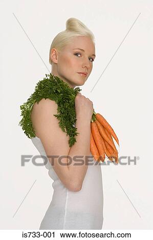 Young woman holding carrots View Large Photo Image Stock Image - Young woman holding carrots. Fotosearch