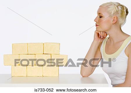 Young woman sat next to blocks of butter View Large Photo Image Stock Image - Young woman sat next to blocks of butter. Fotosearch