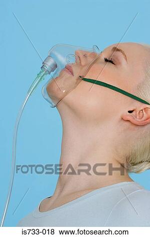 Stock Photo - Young woman wearing an oxygen mask. Fotosearch
