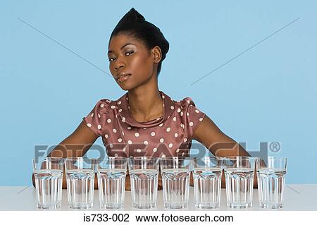 Young woman with eight glasses of water View Large Photo Image Stock Image - Young woman with eight glasses of water. Fotosearch
