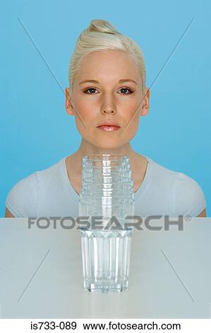 Young woman with glasses of water View Large Photo Image Stock Photo - Young woman with glasses of water. Fotosearch