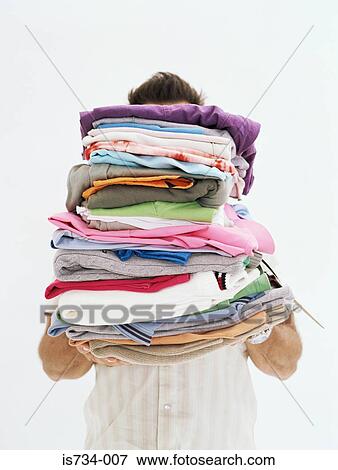 Man with pile of clothes View Large Photo Image Stock Photo - Man with pile of clothes. Fotosearch