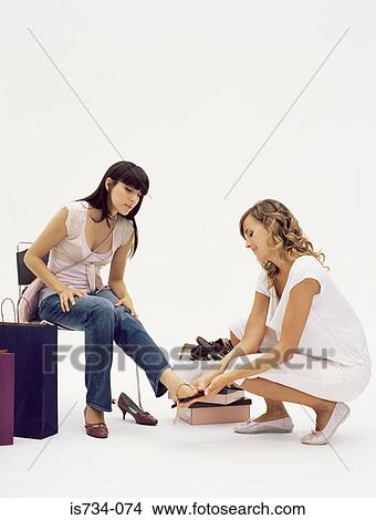Shop assistant helping woman choose shoes View Large Photo Image Picture - Shop assistant helping woman choose shoes. Fotosearch