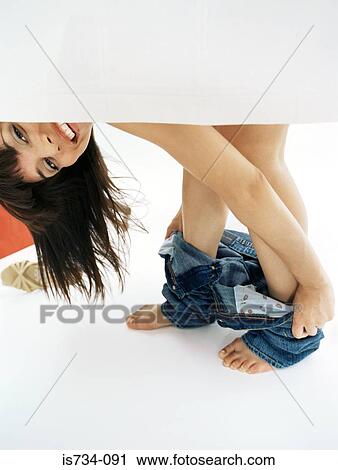 Stock Image - Woman trying on jeans. Fotosearch