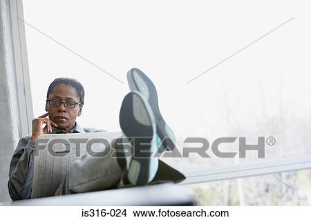 Businesswoman reading a broadsheet newspaper View Large Photo Image Picture - Businesswoman reading a broadsheet newspaper. Fotosearch