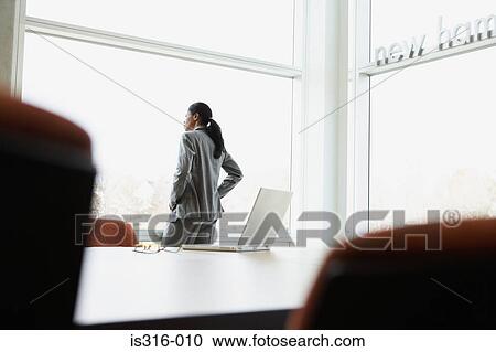 Stock Image - Businesswoman standing in an office. Fotosearch