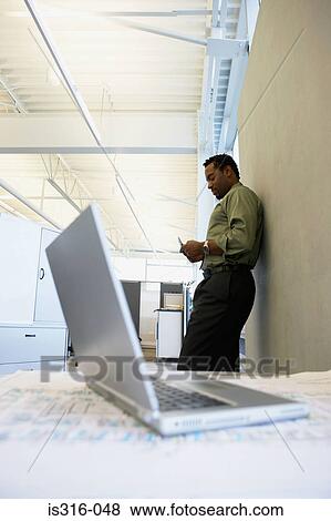 Stock Photo - Male office worker text messaging. Fotosearch