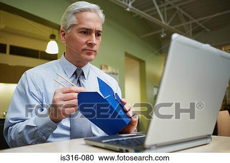 Man eating chinese food at desk View Large Photo Image Stock Image - Man eating chinese food at desk. Fotosearch