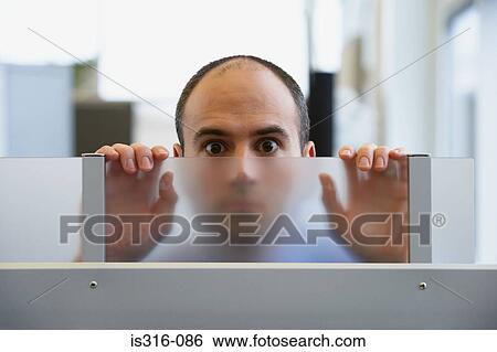 Stock Photograph - Man peering through a glass partition. Fotosearch