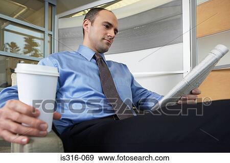 Stock Photo - Man reading a broadsheet newspaper. Fotosearch