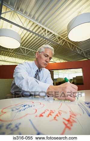 Stock Photography - Man writing on a whiteboard. Fotosearch