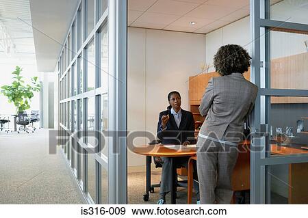 Stock Photo - Two businesswomen talking. Fotosearch