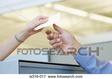 Two colleagues passing a note View Large Photo Image Stock Photo - Two colleagues passing a note. Fotosearch